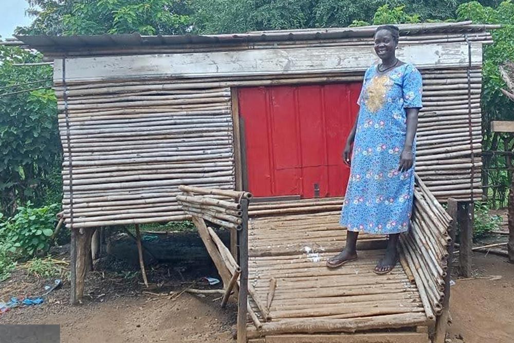 Woman in South Sudan in front of goat housing unit - Zoetis